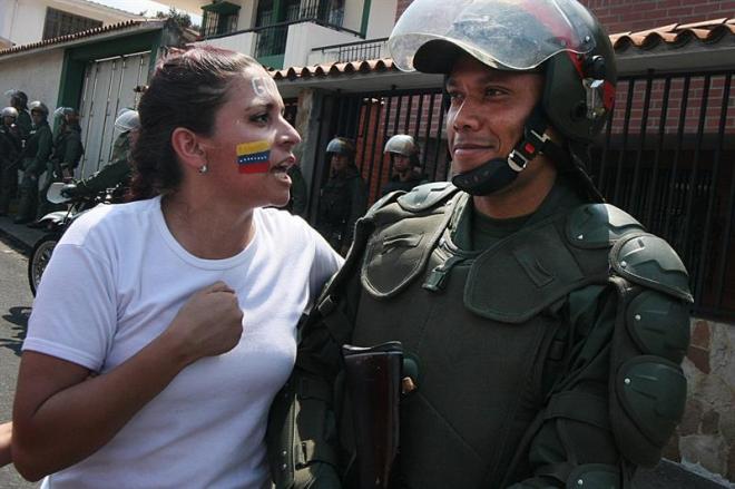 Una manifestante le habla a un policía durante una marcha contra el gobierno de Nicolás Maduro en San Cristobal, Táchira 